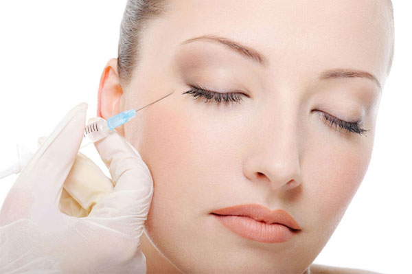 Eine Frau bekommt eine Botulinumtoxin (Botox ®) Spritze am Auge gesetzt